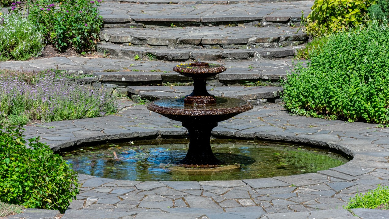 A small fountain in a circular basin with two tiers.
