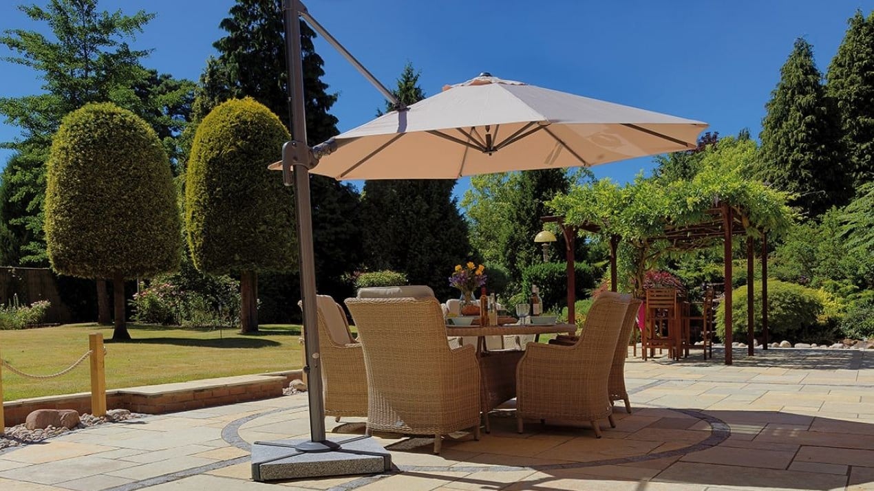 Cantilever parasol providing shade, with a pergola in the background that's covered in climbing plants.