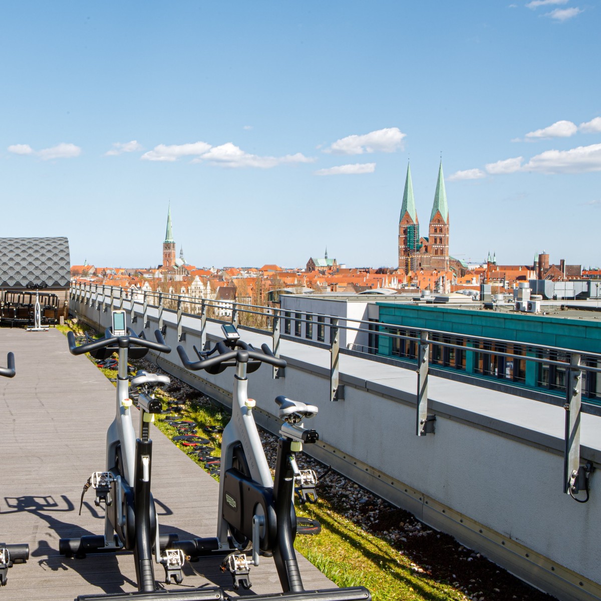 Exercise bikes on rooftop terrace overlooking twin towers of the St. Marien church in the historic city of Luebeck, Germany
