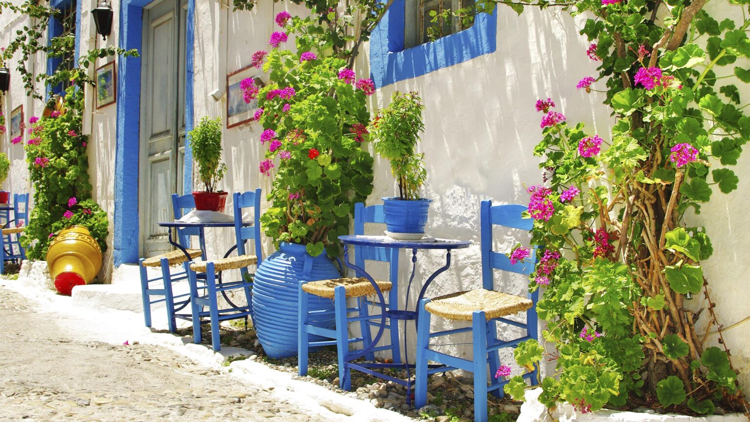 Whitewash walls, vegetation and contrasting blue accent colour on chair, tables, door frames and window frames - Mediterranean garden featrures
